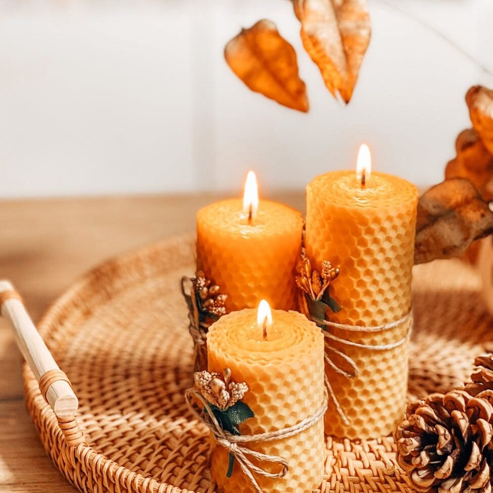 autumn decoration with beeswax candles pine cones and leaves on wicker tray