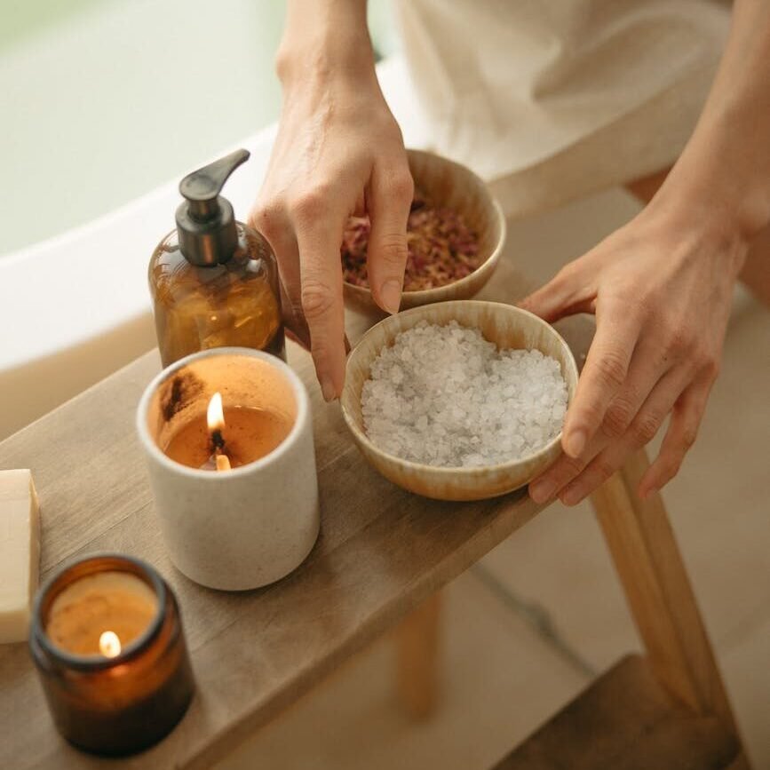 person holding a wooden bowl of salt